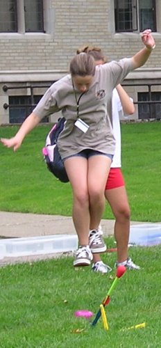 A girl, midair, jumping on a Stomp Rocket.